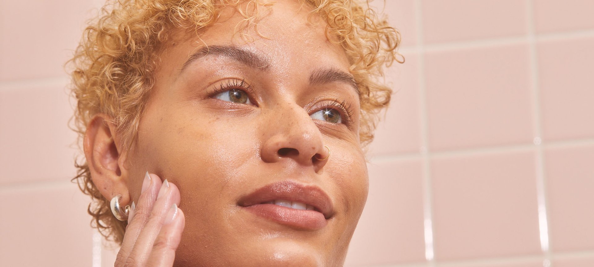 A Person Touching Their Face That Has A Few Freckles