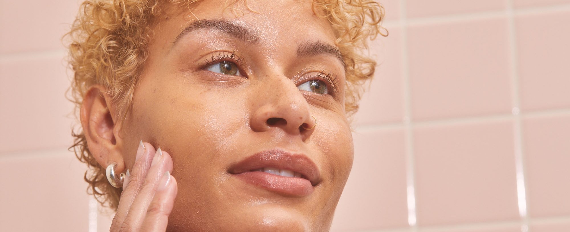 A Person Touching Their Face That Has A Few Freckles