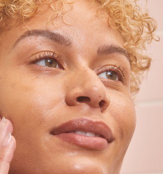 A Person Touching Their Face That Has A Few Freckles