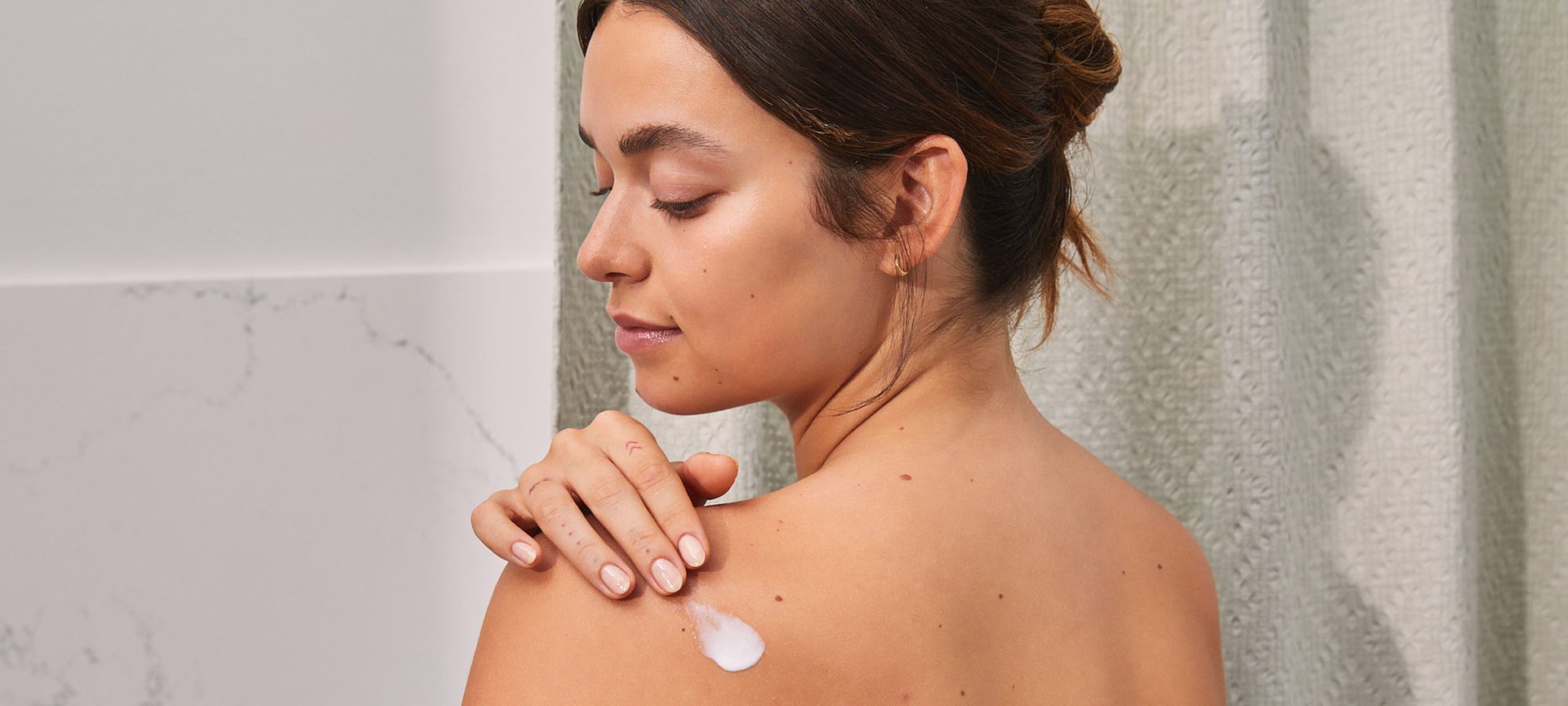 Person Applying Lotion On Their Back