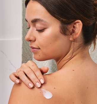 Person Applying Lotion On Their Back