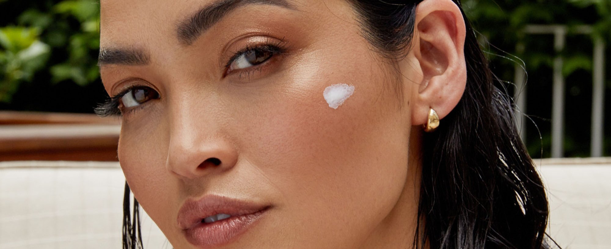 30 something woman with skin care swipe on face
