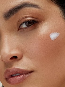30 something woman with skin care swipe on face