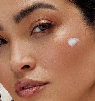 30 something woman with skin care swipe on face