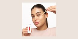 A young girl using a face serum