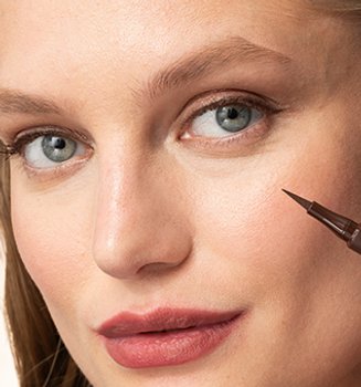 A woman holding a liquid eyeliner