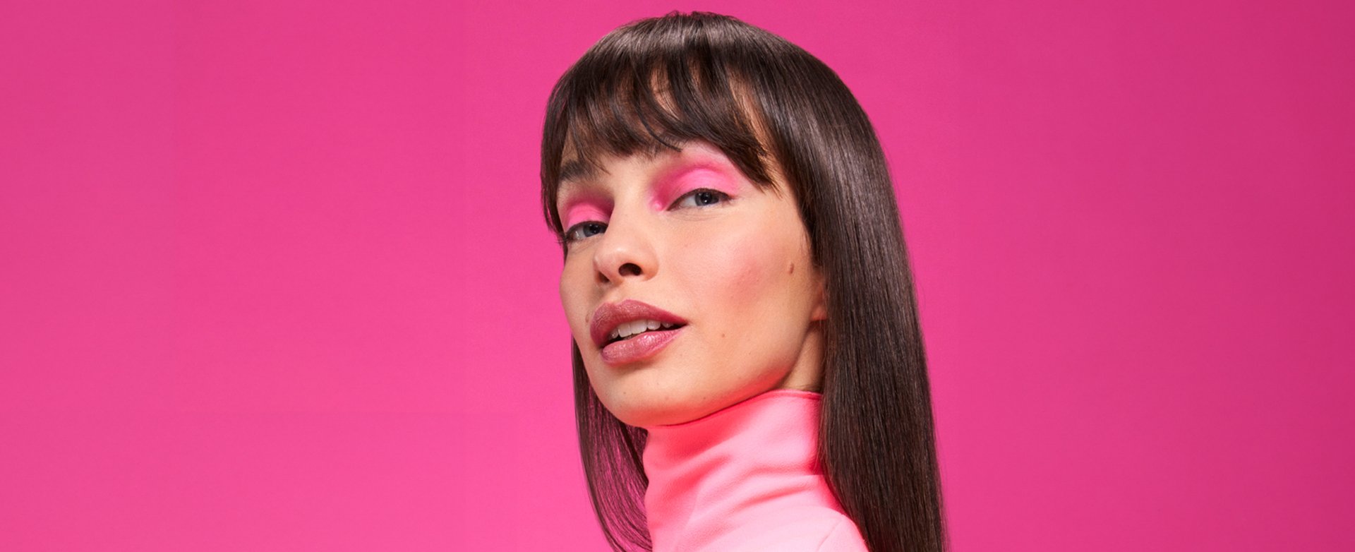 A woman with bold eyeshadow and blunt bangs