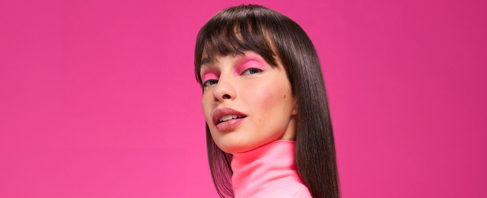 A woman with bold eyeshadow and blunt bangs