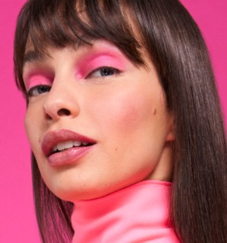 A woman with bold eyeshadow and blunt bangs