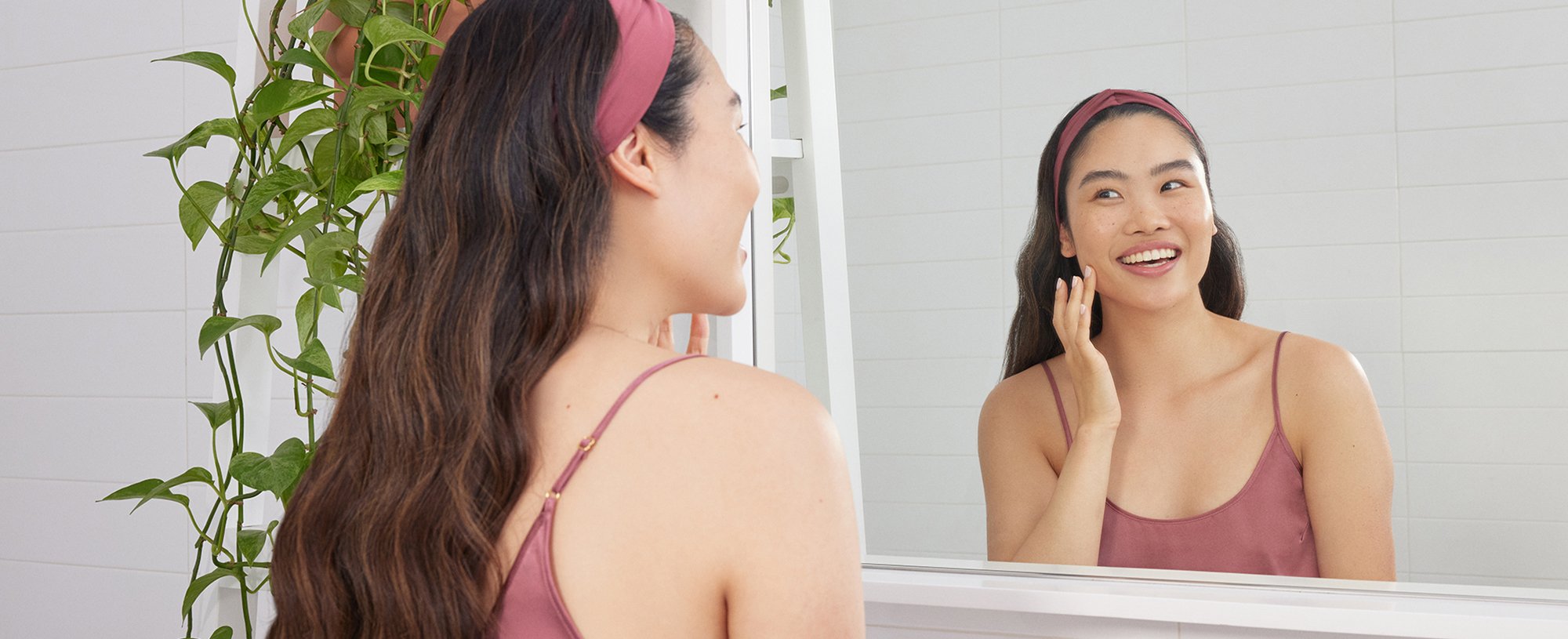 A woman with a cream on face looking in a mirror