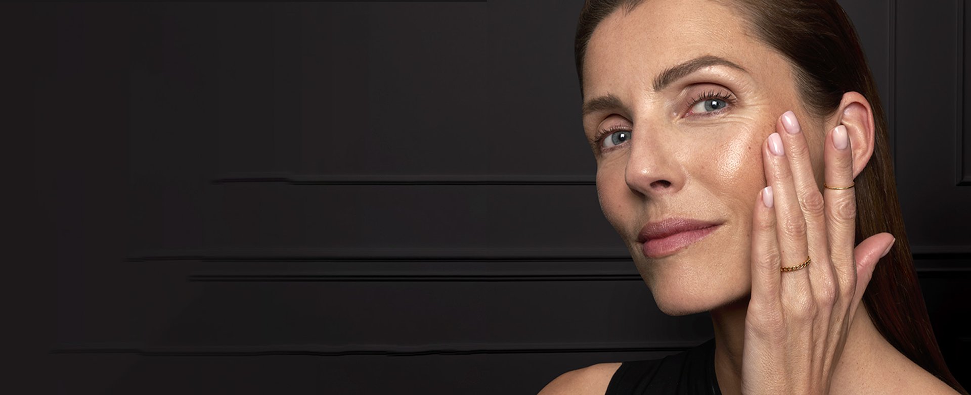 Woman rubbing lotion onto smile lines